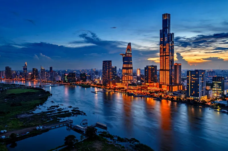 Sunset over the Saigon River with the District 1 skyline glowing across the water from Thu Thiem park